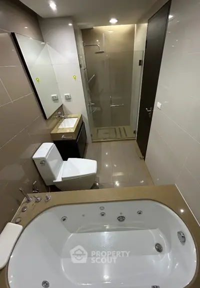 Modern bathroom with jacuzzi tub and glass shower enclosure