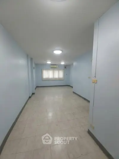 Spacious empty room with tiled flooring and air conditioning, ideal for customization.