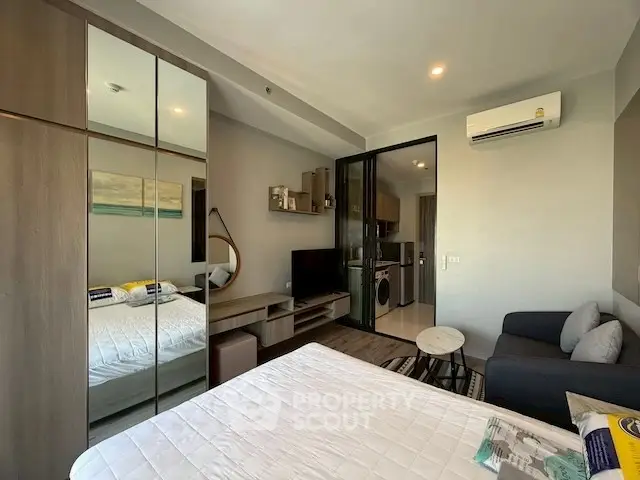 Modern studio apartment with mirrored wardrobe and cozy living area.