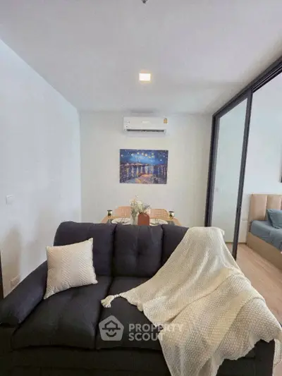 Cozy living room with modern decor and dining area in a stylish apartment.
