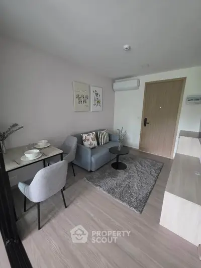 Modern living room with cozy seating and stylish decor in a compact apartment.