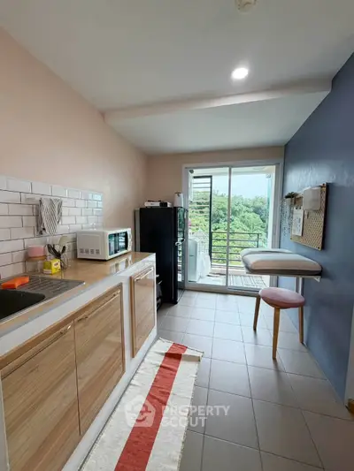 Charming kitchen with open layout and balcony view, featuring modern appliances and stylish decor.