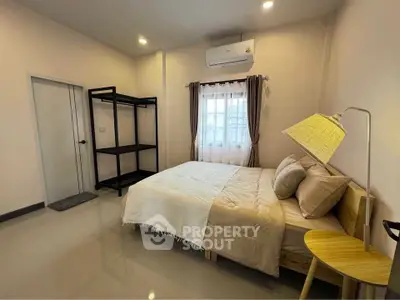 Cozy bedroom with modern decor, featuring a comfortable bed and stylish lighting.