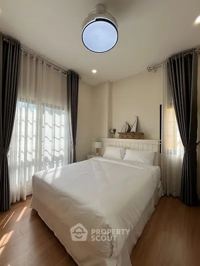 Cozy bedroom with elegant curtains and soft lighting, perfect for relaxation.