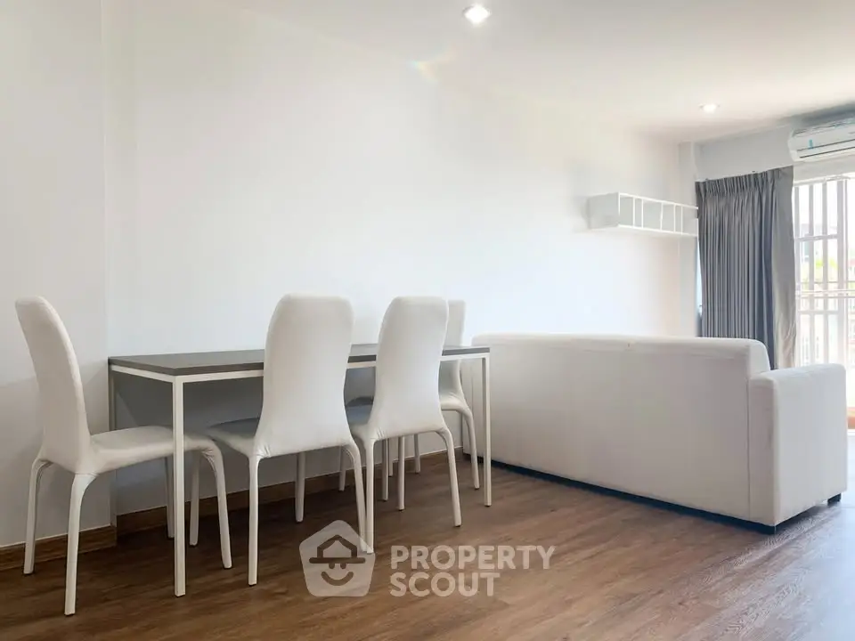 Spacious modern living room with white furniture and wooden flooring