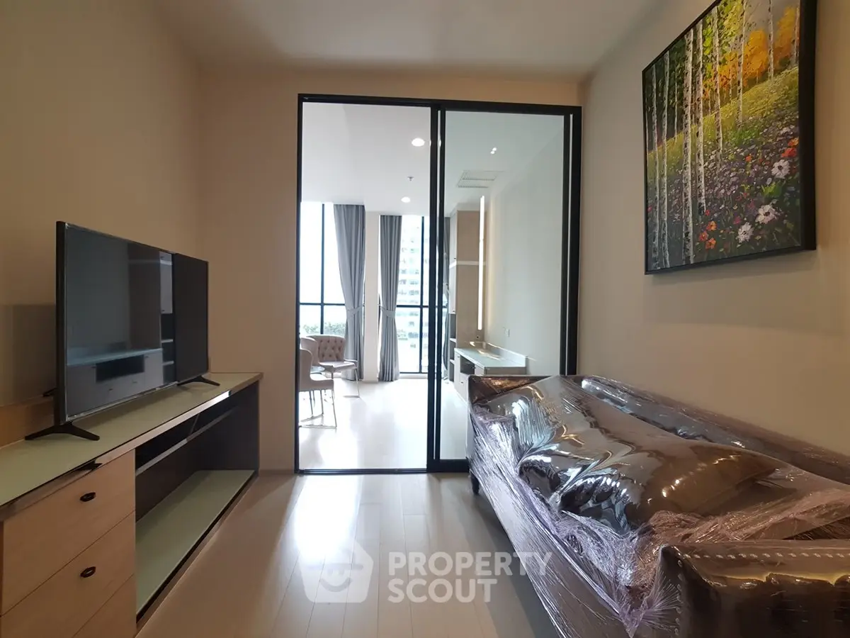 Modern living room with sleek TV setup and stylish decor in a contemporary apartment.