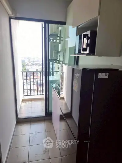 Compact kitchen with balcony view, featuring modern appliances and sleek design for urban living.