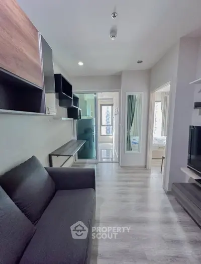 Modern living room with sleek design and natural light, featuring a cozy sofa and stylish shelving.