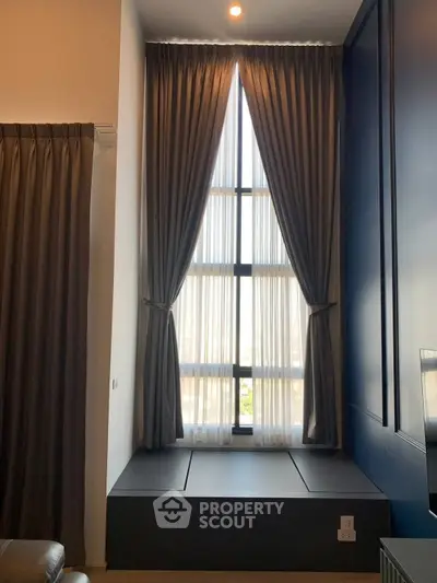 Elegant high-ceiling window with luxurious curtains in modern living space