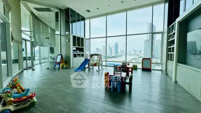 Spacious playroom with stunning city view and modern amenities in luxury high-rise building.