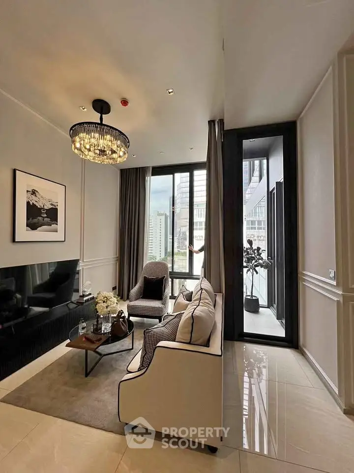 Luxurious living room with elegant decor and city view, featuring a chic chandelier and plush seating.