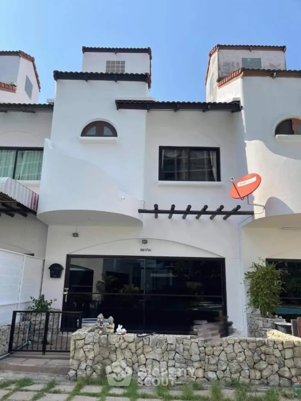 Charming Mediterranean-style townhouse with unique architectural features and lush garden.