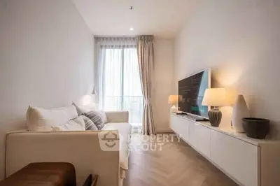 Stylish modern living room with cozy sofa and large TV, perfect for relaxation.
