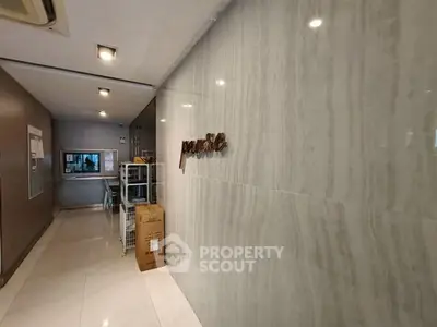 Modern building entrance with marble walls and sleek design, showcasing luxury and elegance.