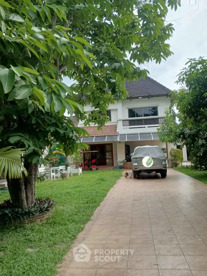 Charming two-story house with lush garden and driveway, perfect for family living.