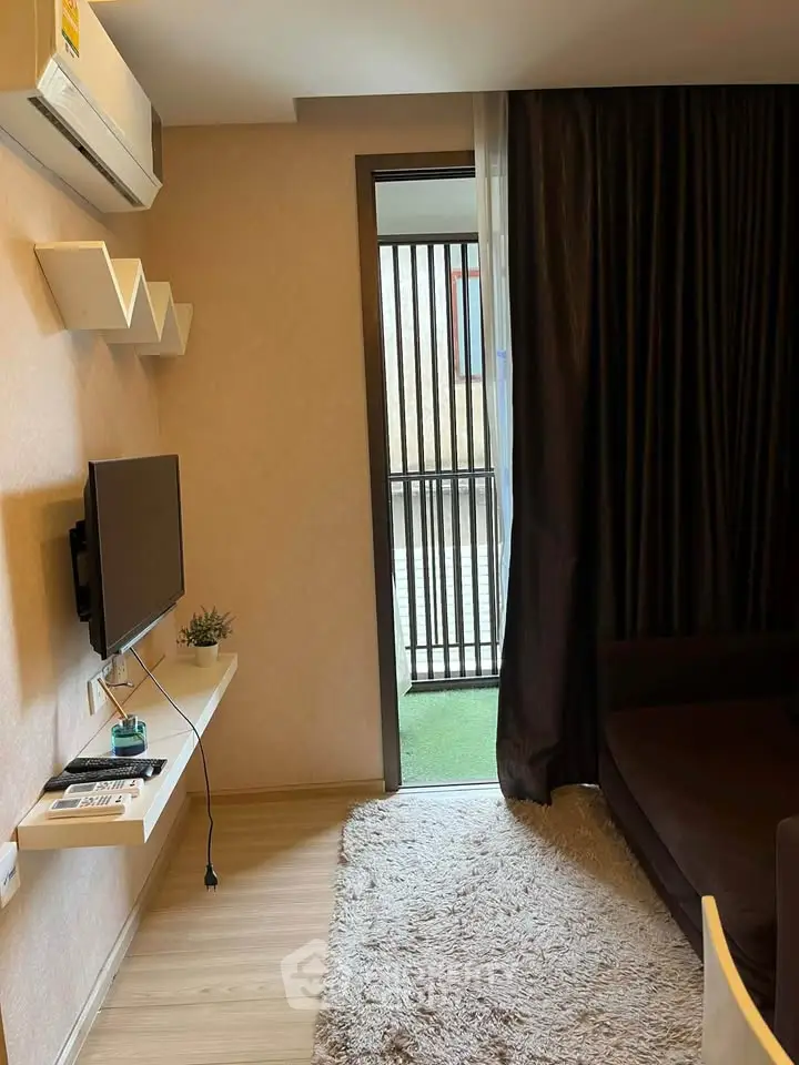 Cozy living room with modern decor and balcony access in a stylish apartment.