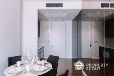 Sleek modern dining area with mirrored wall, elegant table setting, and sophisticated neutral tones, perfect for intimate gatherings and stylish living.