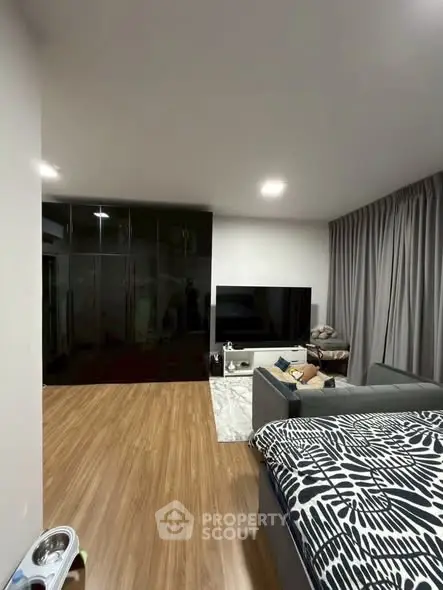 Modern living room with sleek black wardrobe and cozy sofa setup.