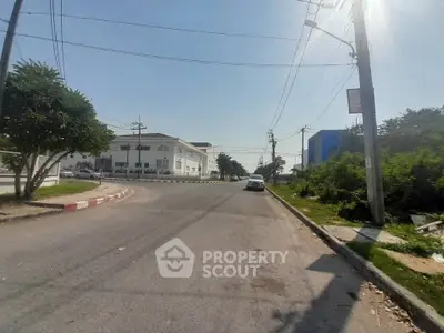 Spacious street view with modern buildings and lush greenery, ideal for commercial real estate opportunities.
