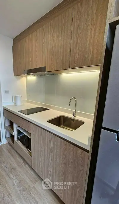 Modern kitchen with sleek wooden cabinets and stainless steel appliances