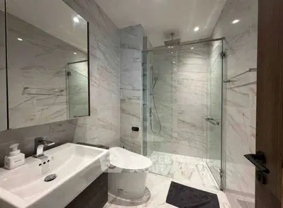 Luxurious modern bathroom with marble tiles and glass shower enclosure