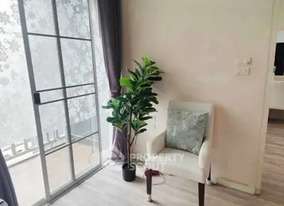 Cozy corner with elegant chair and potted plant by a sliding glass door in a modern apartment.