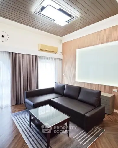 Modern living room with sleek black sofa and stylish lighting