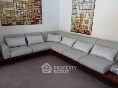 Spacious living room with modern sectional sofa and stylish wall art, perfect for relaxation and entertaining.