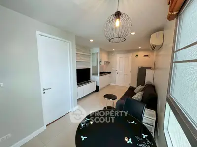 Modern living room with stylish decor and natural light, featuring a cozy seating area and contemporary lighting.
