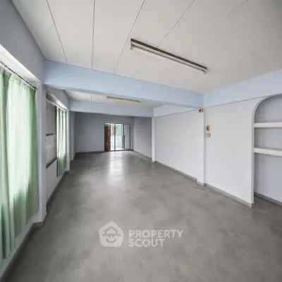 Spacious empty room with large windows and natural light, perfect for customization.