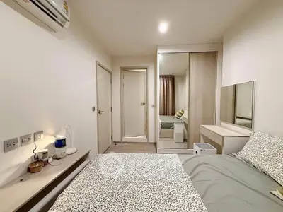 Cozy bedroom with modern decor and mirrored wardrobe in a stylish apartment.