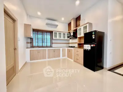 Modern kitchen with sleek cabinetry and black refrigerator in a bright, spacious layout.