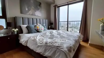 Luxurious bedroom with city view, elegant decor, and large windows for natural light.