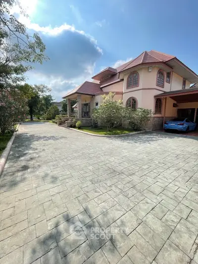 Stunning two-story house with spacious driveway and lush garden, perfect for luxurious living.