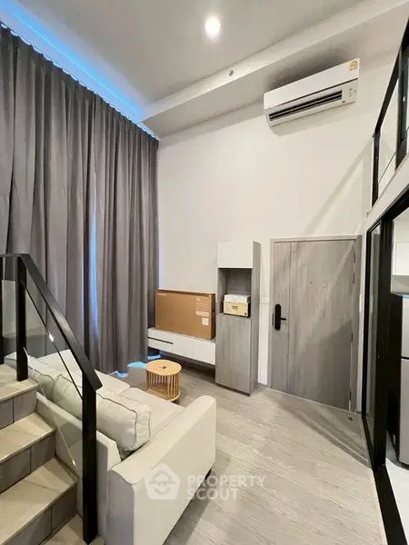 Modern living room with high ceiling and stylish decor in a contemporary apartment.