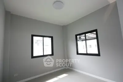 Bright empty room with large windows and neutral tones, perfect for customization.