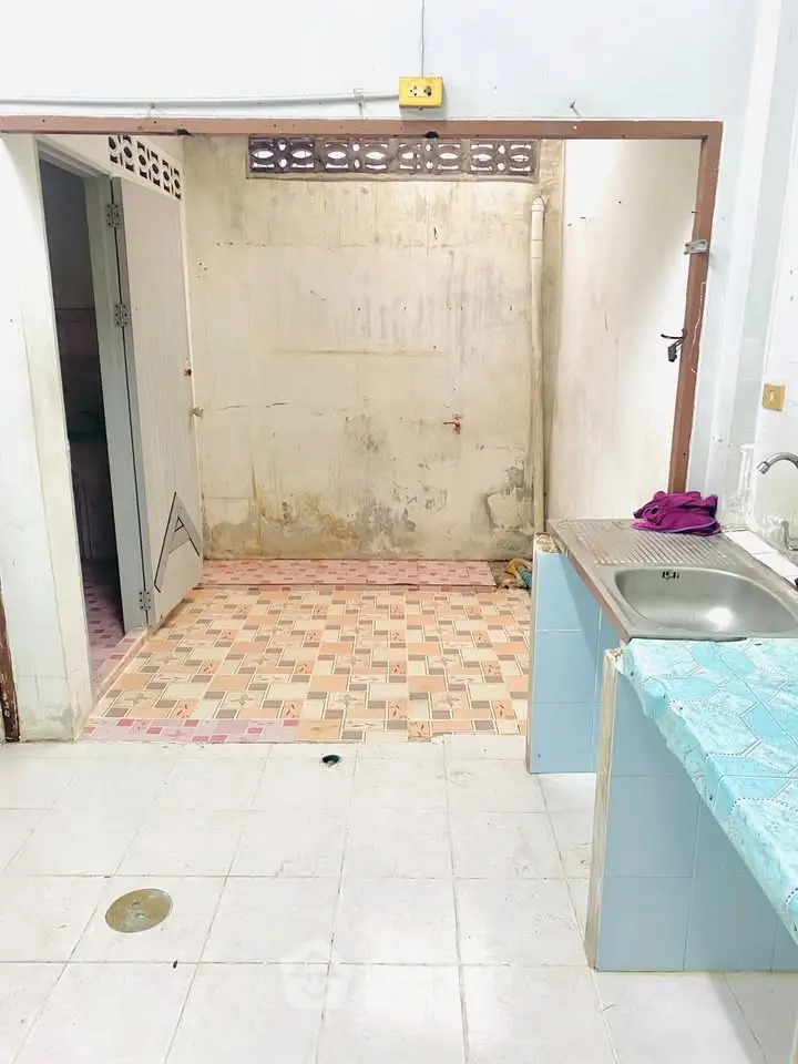 Basic kitchen area with tiled floor and simple sink setup