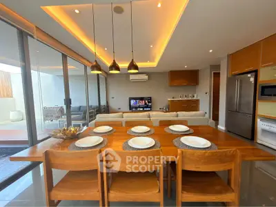 Modern open-plan living and dining area with stylish lighting and large windows.