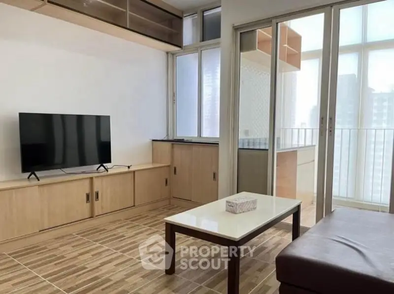 Modern living room with sleek TV unit and balcony access