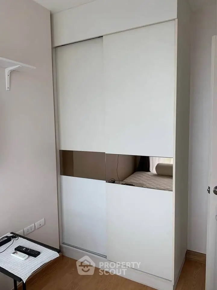 Modern bedroom with sleek white wardrobe and wooden flooring