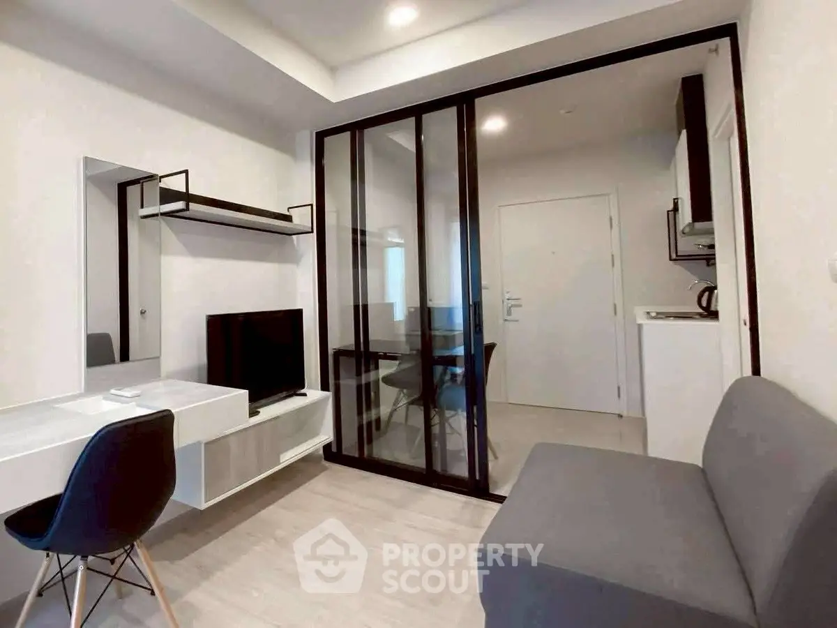 Modern living room with sleek furniture and glass partition in a stylish apartment.