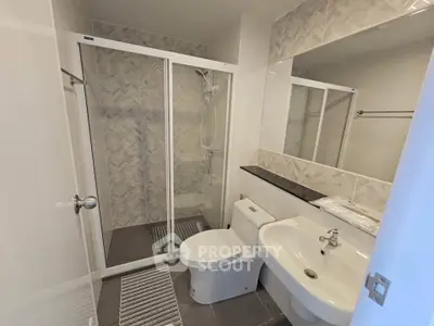 Modern bathroom with glass shower and sleek fixtures in a contemporary apartment.