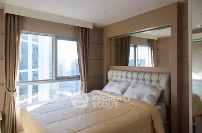 Luxurious bedroom with city view and elegant decor in high-rise apartment.