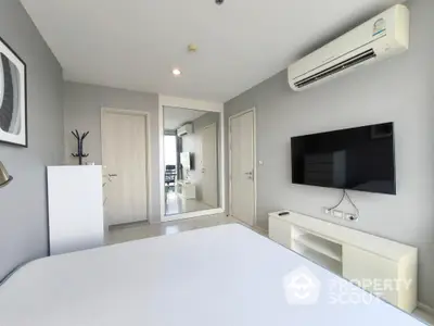 Modern bedroom with sleek design, featuring a wall-mounted TV and air conditioning.