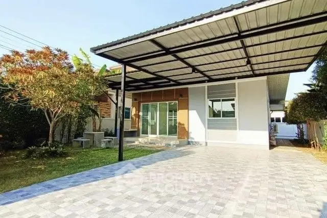 Modern single-story house with spacious driveway and garden area.