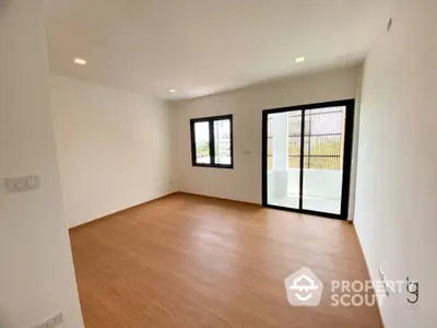 Spacious and bright living room with elegant wooden flooring, large windows, and direct access to a private balcony, ideal for entertaining and relaxation.