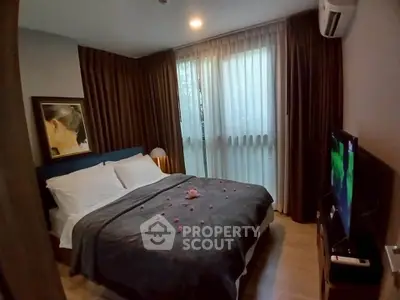 Cozy bedroom with elegant decor and natural light, featuring a comfortable bed and modern amenities.