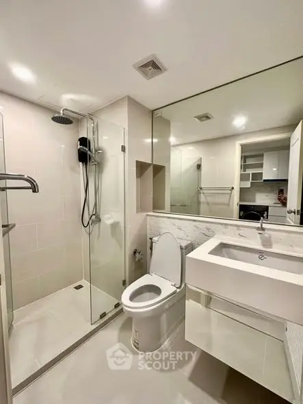 Modern bathroom with glass shower and sleek fixtures in a contemporary home.