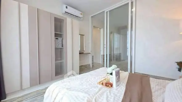 Modern bedroom with sleek design and built-in wardrobe, featuring a cozy bed and elegant decor.