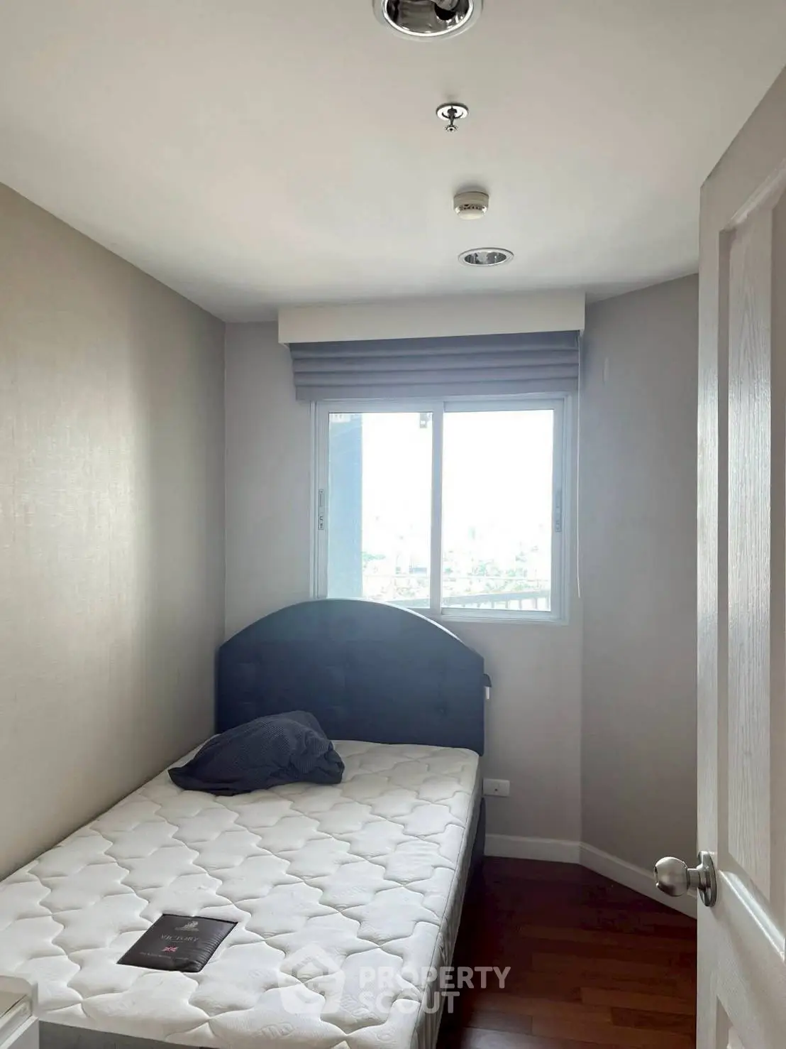 Cozy bedroom with single bed and window view, perfect for a compact living space.